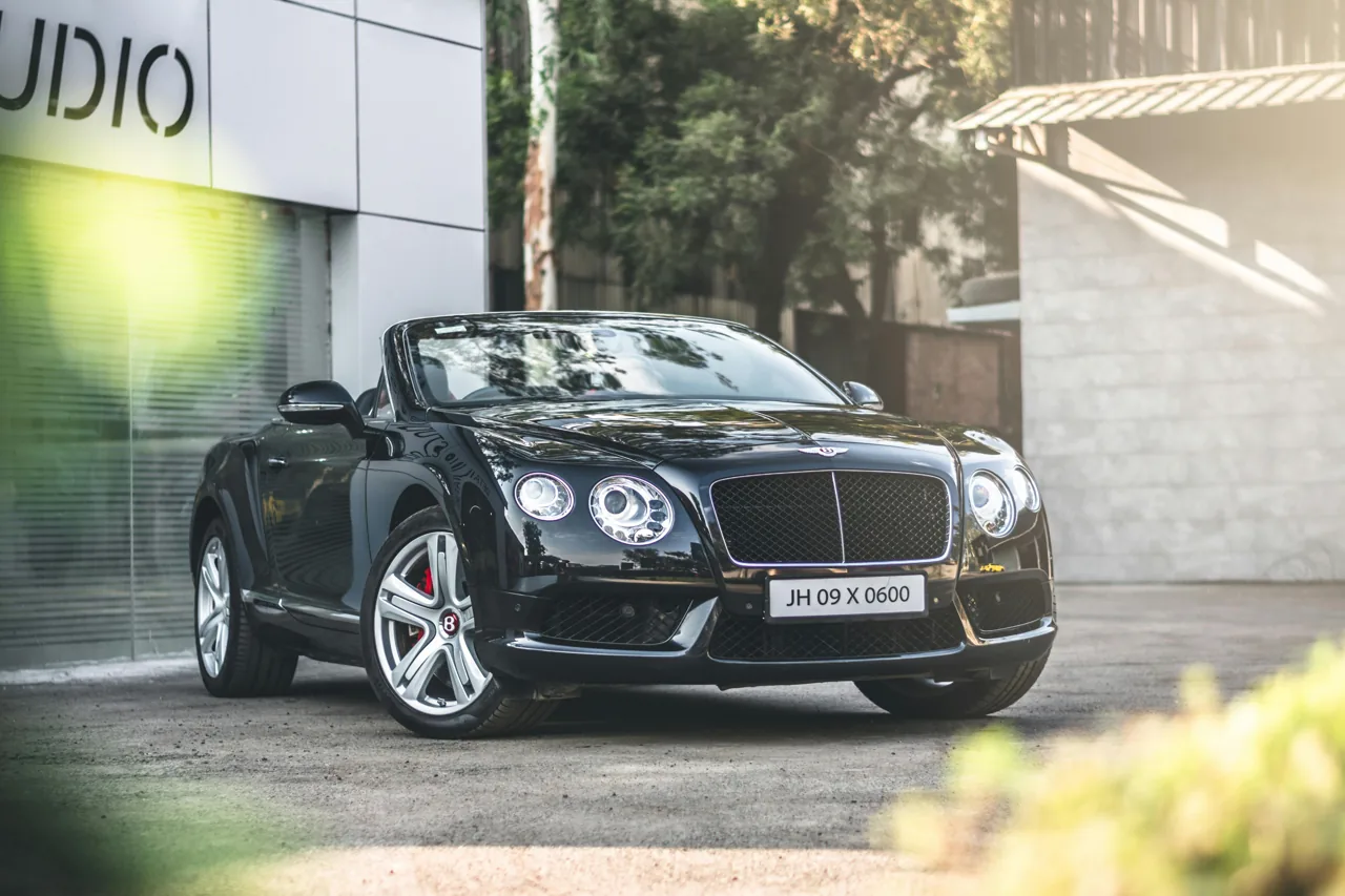 Dark Bentley convertible parked with its roof lowered
