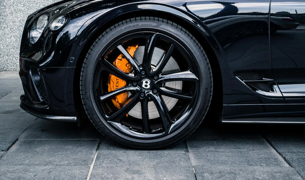 Dark alloy wheel with an orange brake calliper