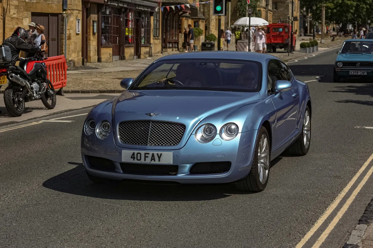 Silver Bentley saloon parked on a street
